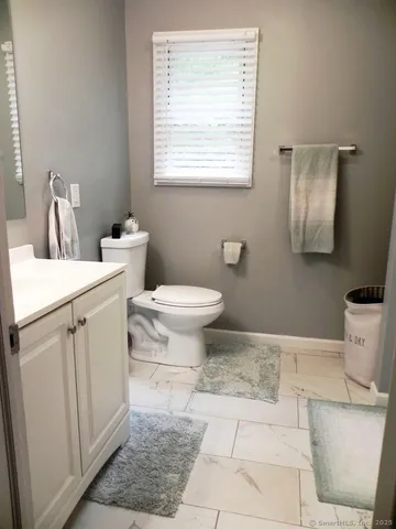 a bathroom with a toilet a sink and a mirror