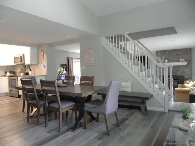 a view of a dining room with furniture a rug and wooden floor