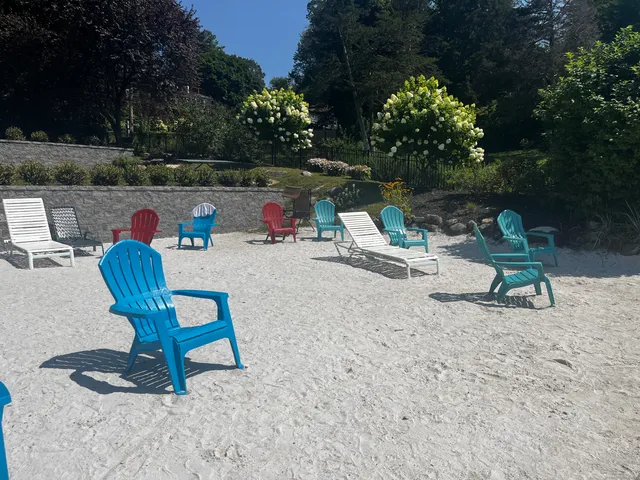 a view of backyard with seating space and trees in the background