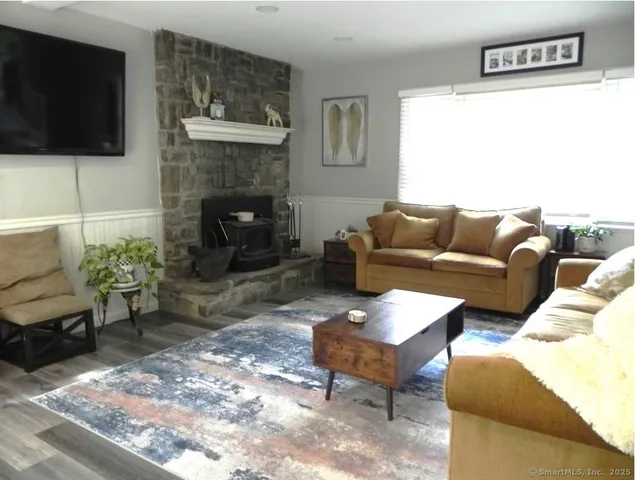a living room with furniture a flat screen tv and a fireplace