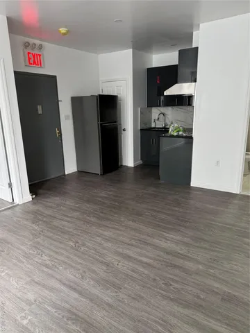 a view of kitchen with refrigerator and window