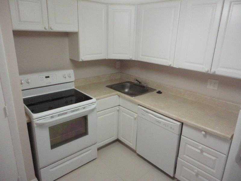 4166 Inverrary Drive, Unit 307 Lauderhill, FL 33319 - Photo 10 of 17 a kitchen with white cabinets and white appliances
