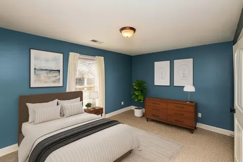 a bedroom with a bed and a potted plant