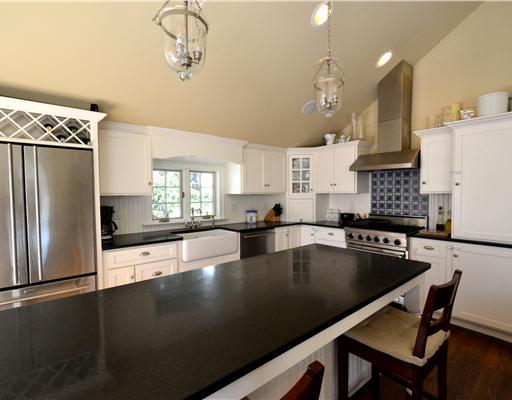 47 Sinawoy Road Cos Cob, CT 06807 - Photo 4 of 10 a view of a kitchen with kitchen island a stove a refrigerator and a dining table with wooden floor