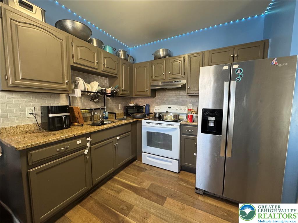 414 Washington Street Allentown, PA 18102 - Photo 6 of 23 a kitchen with stainless steel appliances granite countertop a refrigerator sink and cabinets