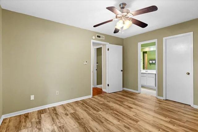 a view of a livingroom with a chandelier fan and wooden floor