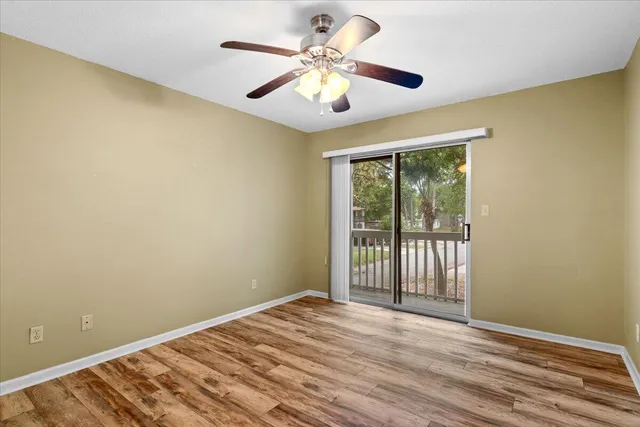 a view of a room with wooden floor and a ceiling fan