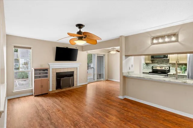 a living room with stainless steel appliances furniture a fireplace and a flat screen tv