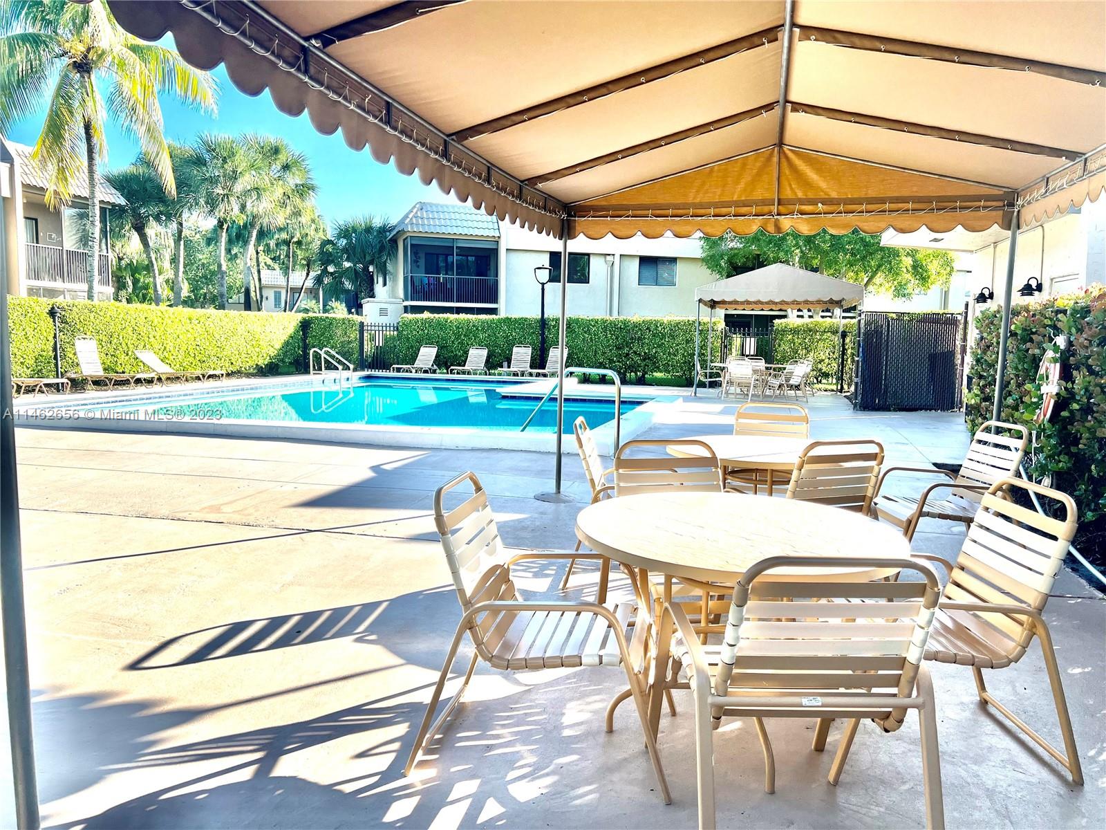 380 Racquet Club Road, Unit 202 Weston, FL 33326 - Photo 2 of 34 a view of a patio with a table and chairs under an umbrella