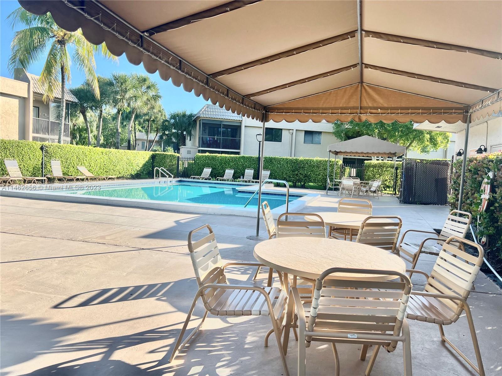 380 Racquet Club Road, Unit 202 Weston, FL 33326 - Photo 21 of 34 a view of a patio with couches table chairs and floor to ceiling window