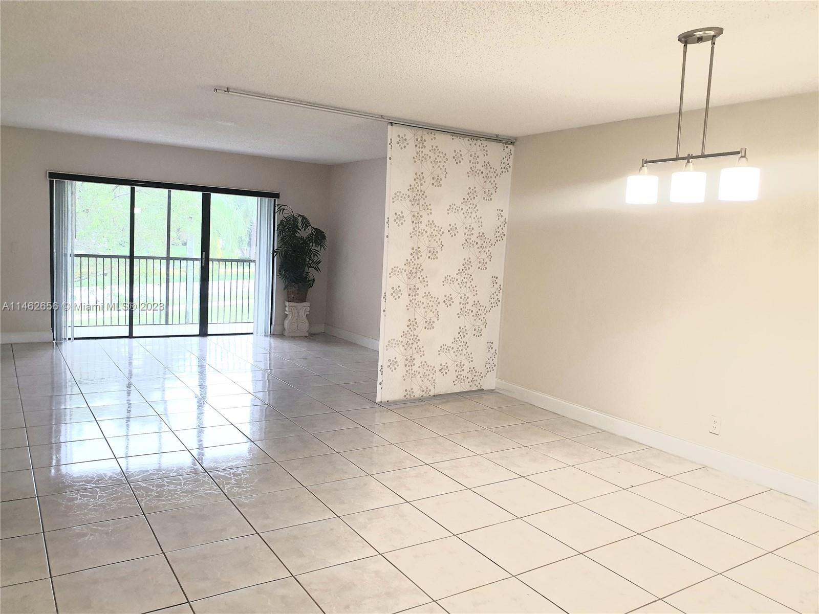380 Racquet Club Road, Unit 202 Weston, FL 33326 - Photo 3 of 34 a view of empty room with wooden floor and fan