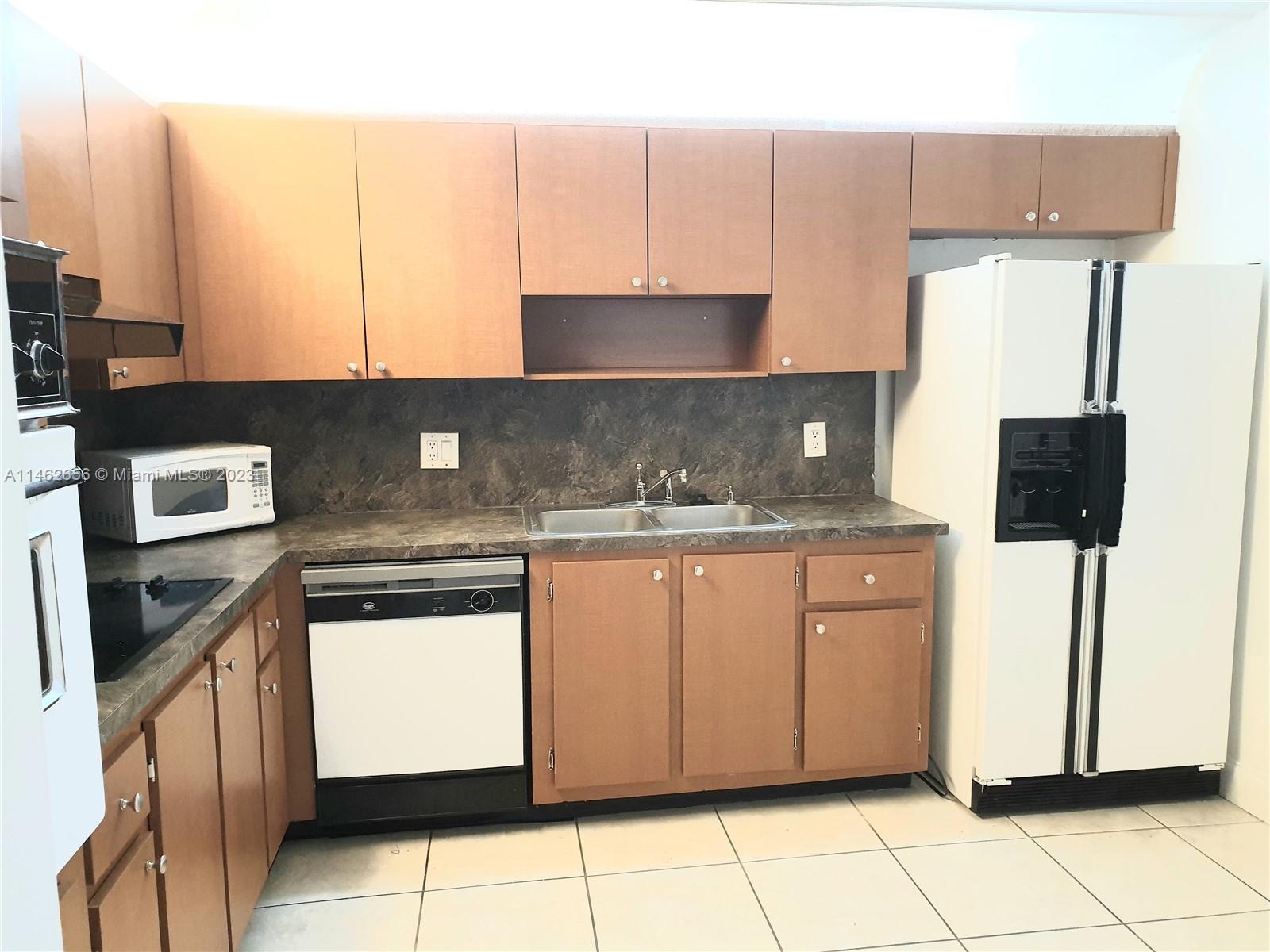 380 Racquet Club Road, Unit 202 Weston, FL 33326 - Photo 7 of 34 a kitchen with stainless steel appliances granite countertop a sink stove and refrigerator