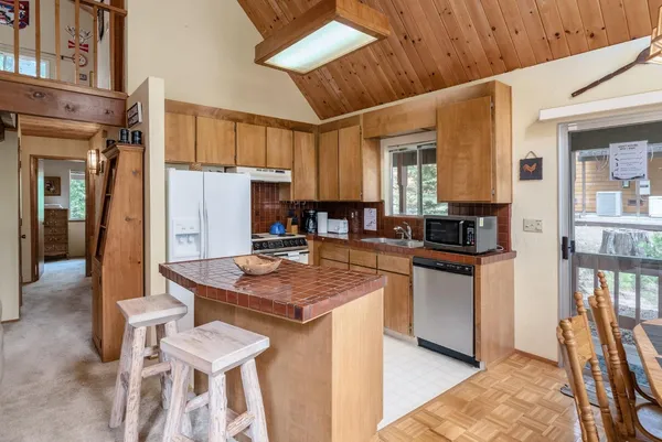 a kitchen with stainless steel appliances granite countertop a stove refrigerator and a dining table with wooden floor