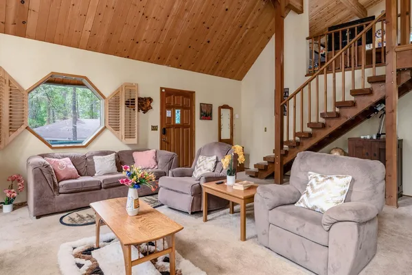 a living room with furniture a rug and a large window