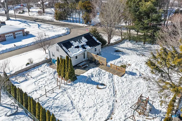a view of a house with a yard covered with snow in the background