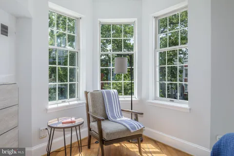 a bedroom with a bed and a lamp next to a window