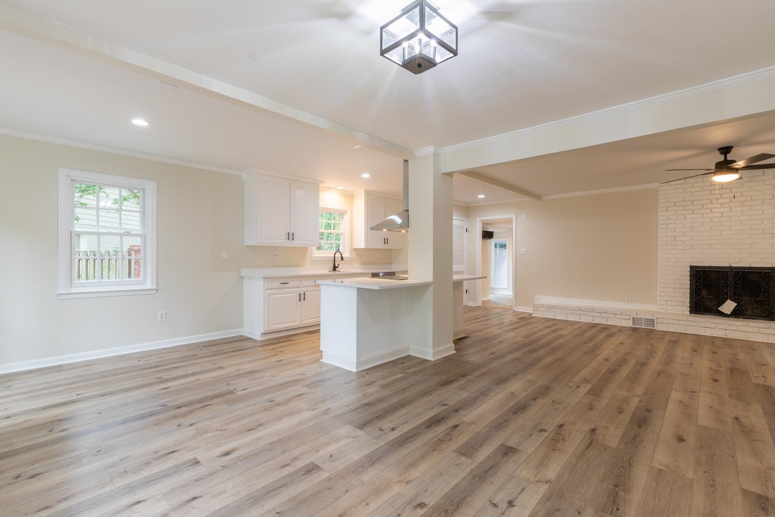 505 Thorn Ridge Cove Memphis, TN 38117 - Photo 11 of 31 Kitchen with ceiling fan, light hardwood / wood-style flooring, a fireplace, ornamental molding, and white cabinets