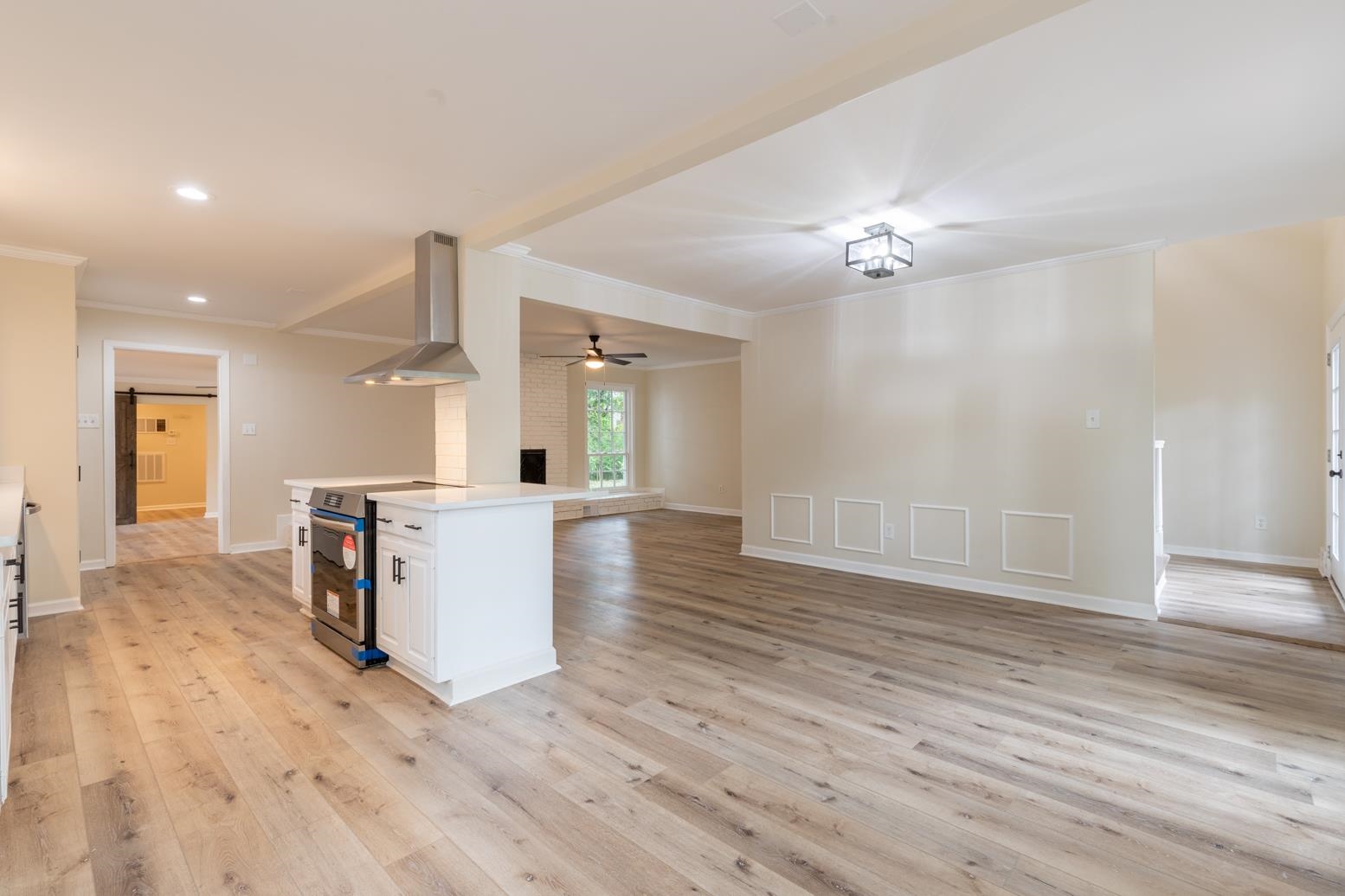 505 Thorn Ridge Cove Memphis, TN 38117 - Photo 12 of 31 Kitchen with ceiling fan, range with electric stovetop, white cabinetry, wall chimney exhaust hood, and light wood-type flooring