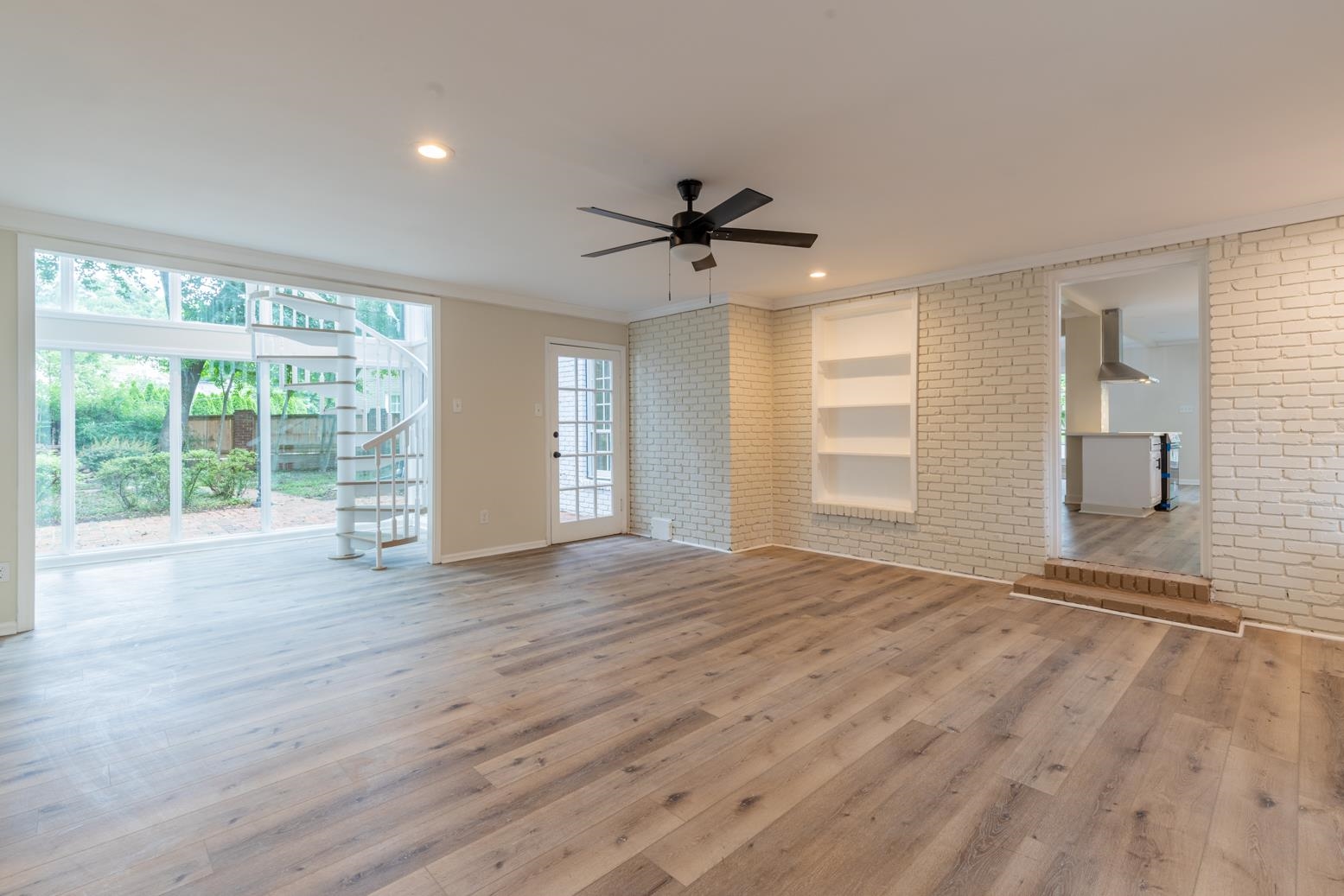 505 Thorn Ridge Cove Memphis, TN 38117 - Photo 17 of 31 Unfurnished living room with ceiling fan, hardwood / wood-style floors, and brick wall