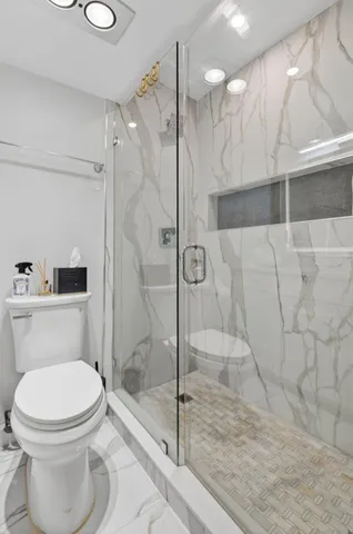 a bathroom with a toilet and a shower