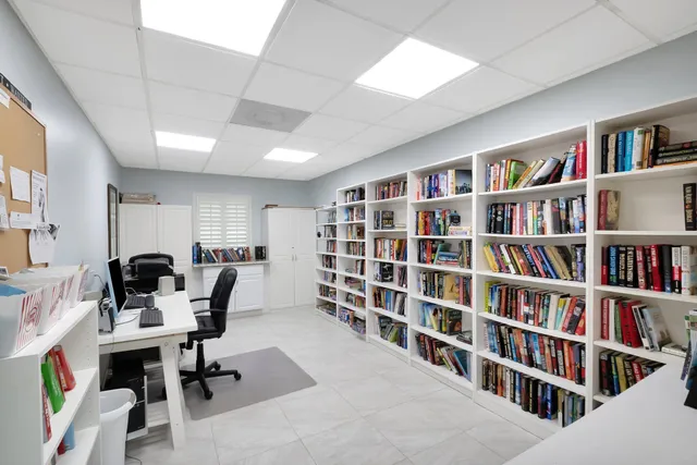 a view of a livingroom with workspace and a bookshelf