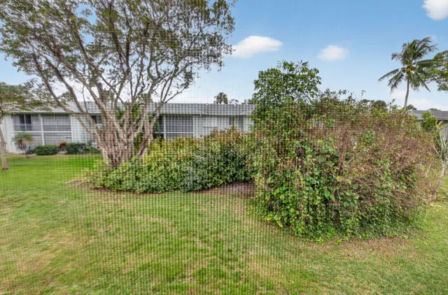 a view of a house with a tree and a yard