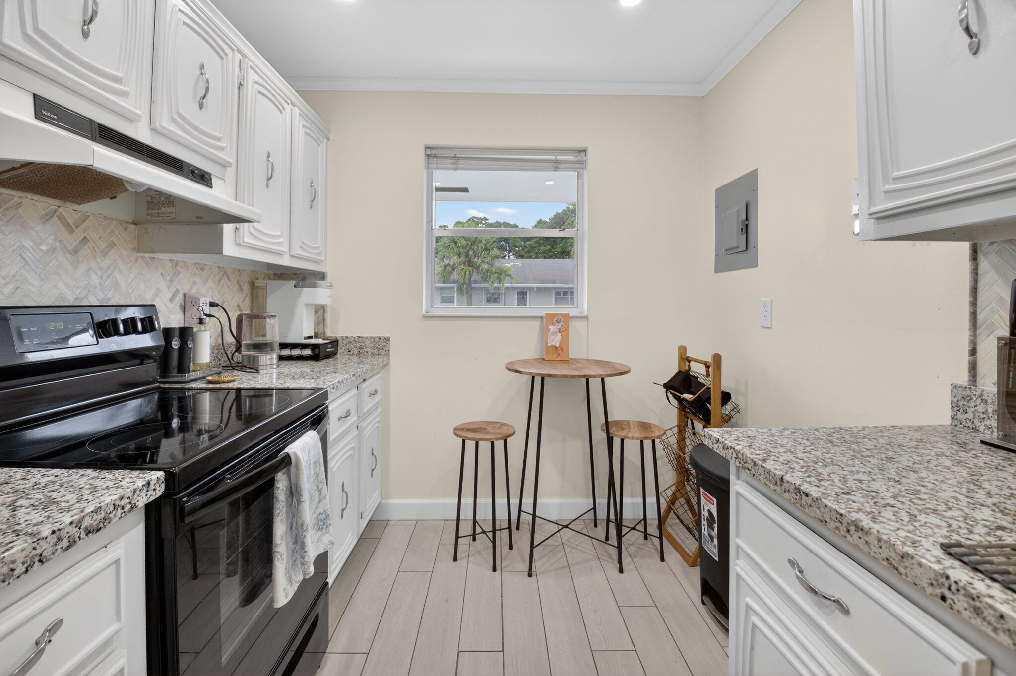 2340 Southwest 22nd Avenue, Unit 312 Delray Beach, FL 33445 - Photo 6 of 45 a kitchen with granite countertop a stove top oven a sink a counter space and cabinets
