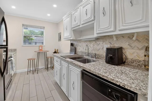 a kitchen with stainless steel appliances granite countertop a sink stove and cabinets