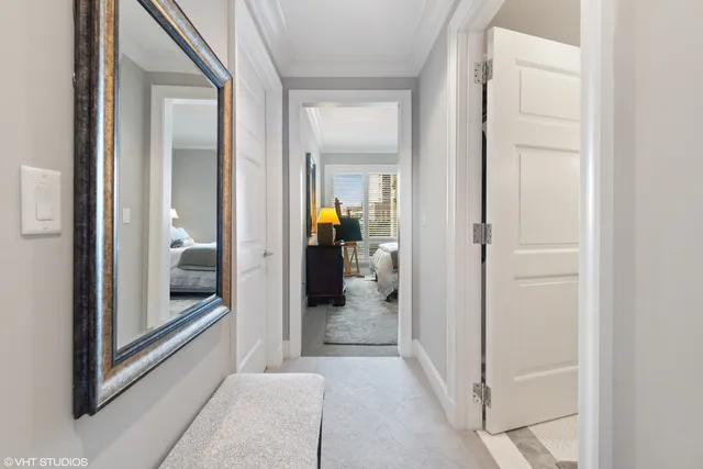 a view of a hallway with wooden floor and a living room