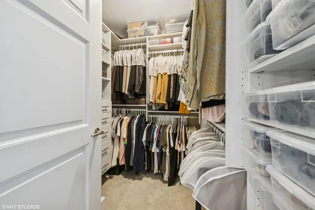a view of walk in closet with clothes and shoes