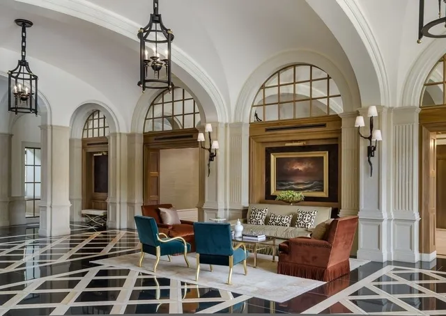 a living room with furniture a fireplace and a chandelier
