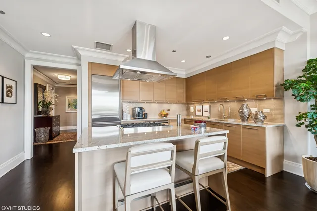 a kitchen with kitchen island granite countertop wooden floor and stainless steel appliances