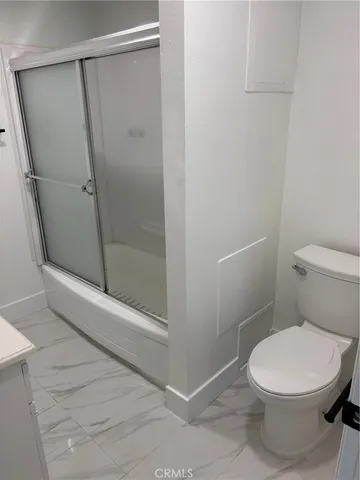 a white toilet sitting next to a shower