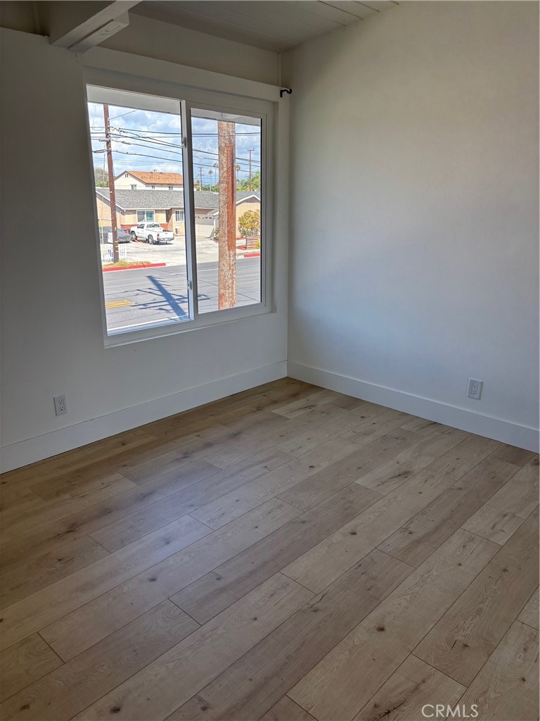 7160 Cerritos Avenue Stanton, CA 90680 - Photo 10 of 10 a view of an empty room with wooden floor and a window