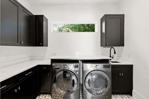 a utility room with sink dryer and washer