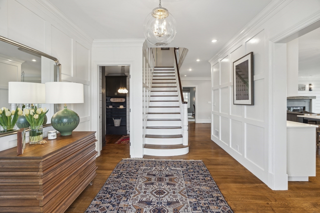 24 Greystone Road Marblehead, MA 01945 - Photo 7 of 42 a hallway with wooden floor white walls and stairs