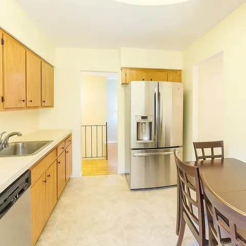 a kitchen with stainless steel appliances granite countertop a refrigerator a stove and a sink with granite countertops