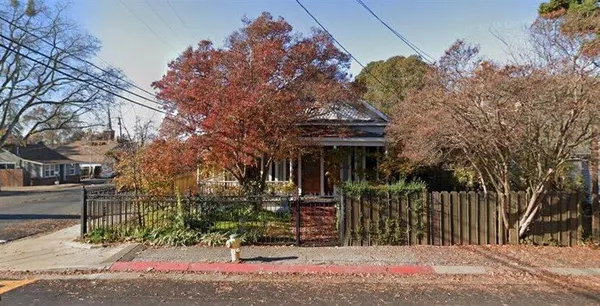 a front view of a house with a tree