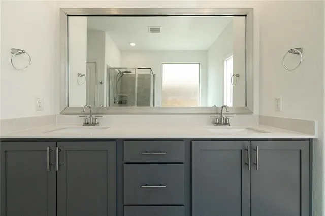 a en suite bathroom with a granite countertop sink and a mirror