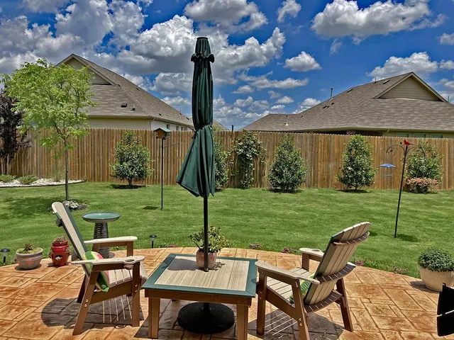 a view of a patio with a table chairs and a yard