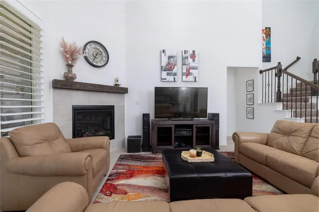 a living room with furniture a flat screen tv and a fireplace with a bookshelf