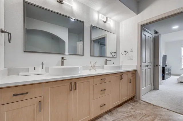 a bathroom with double sink and a mirror
