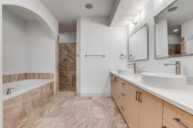 a spacious bathroom with a double vanity sink and a bathtub