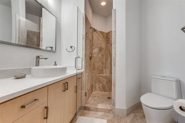 a bathroom with a granite countertop sink toilet and shower