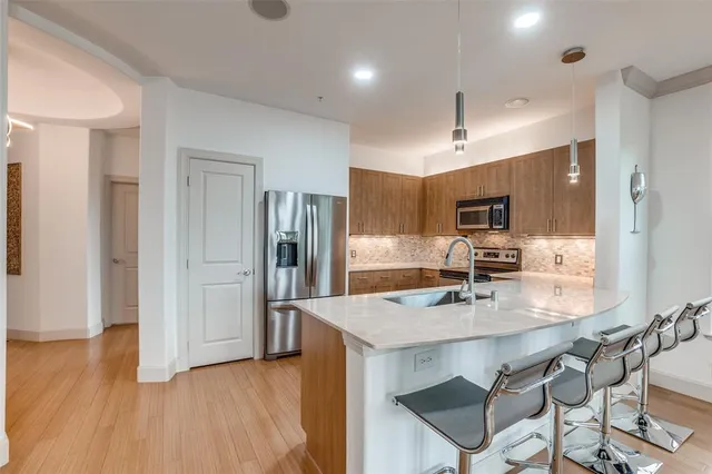 a kitchen with kitchen island a sink refrigerator and cabinets