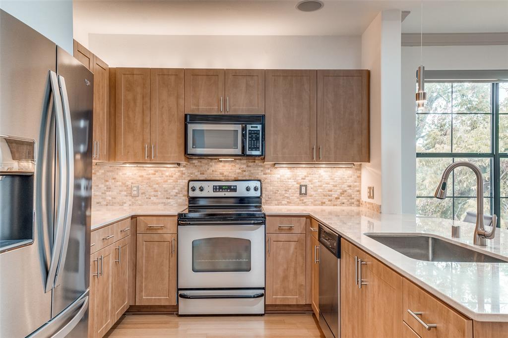 3818 Holland Avenue, Unit 309 Dallas, TX 75219 - Photo 4 of 24 a kitchen with granite countertop a stove microwave and sink