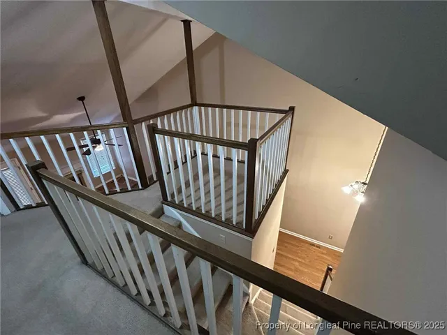an empty room with a chandelier fan and windows