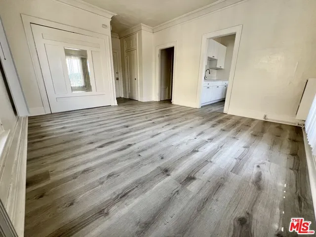 an empty room with wooden floor and closet