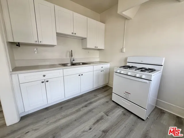 a kitchen with granite countertop white cabinets and white appliances