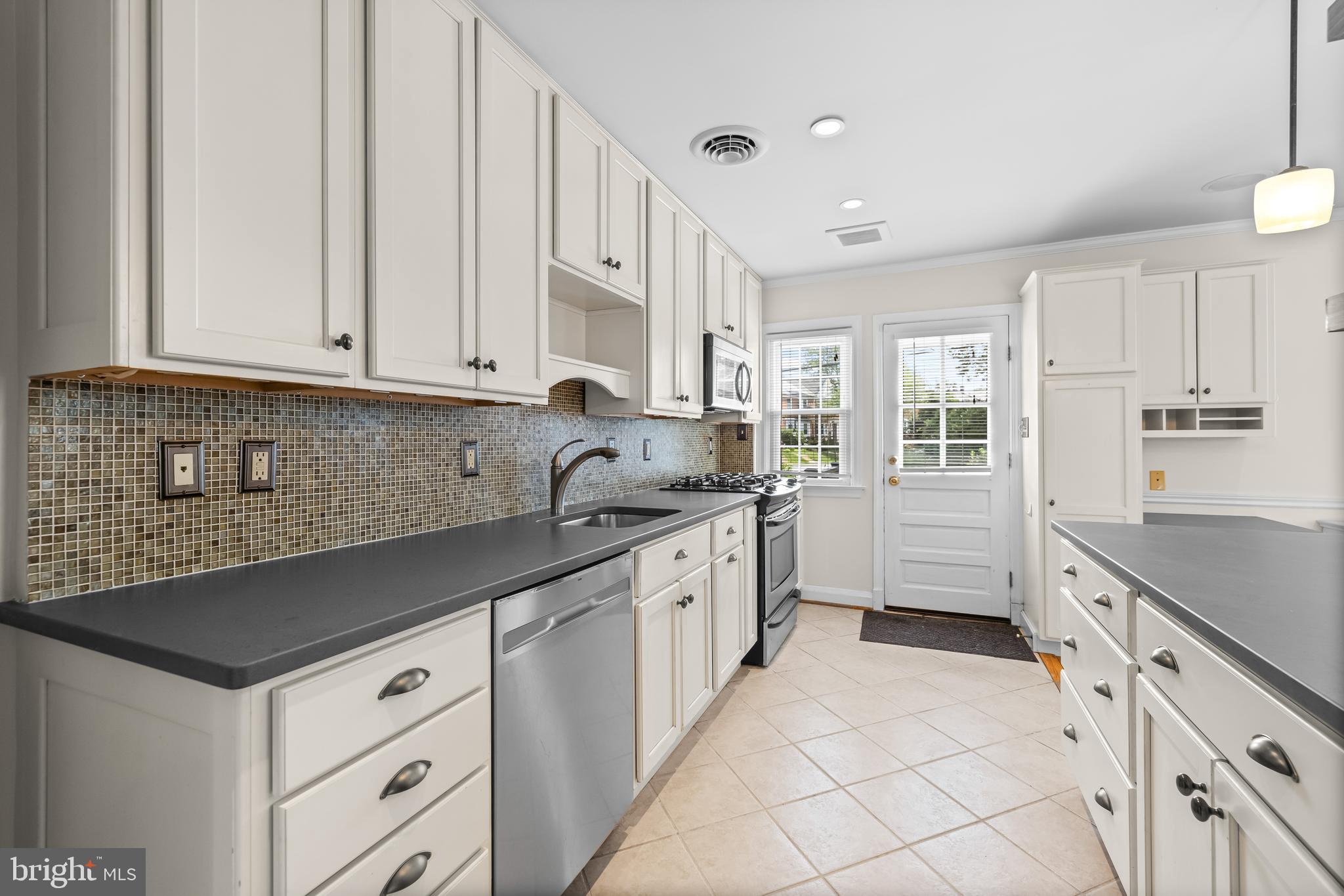 6449 Blenheim Road Baltimore, MD 21212 - Photo 17 of 36 a kitchen with granite countertop white cabinets and white appliances